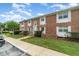 Charming brick townhouse with white shutters, a manicured lawn, and lovely landscaping at 4300 Lake Underhill Rd # D, Orlando, FL 32803