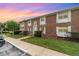 Charming brick townhouse with white shutters, a manicured lawn, and lovely landscaping at 4300 Lake Underhill Rd # D, Orlando, FL 32803