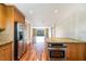 Bright kitchen featuring wooden cabinets, stainless steel appliances, granite counters, and a warm hardwood floor at 4300 Lake Underhill Rd # D, Orlando, FL 32803