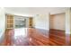 Spacious living room with hardwood floors, built-in shelving, and sliding glass doors to a balcony at 4300 Lake Underhill Rd # D, Orlando, FL 32803