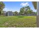 Large, grassy backyard with a shed and mature trees at 510 Peach Tree Ln, Altamonte Springs, FL 32701