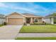Charming single-story home featuring a well-manicured lawn, neutral color palette, and attached two-car garage at 5416 Tessin Trl, St Cloud, FL 34771