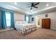 Spacious main bedroom features tray ceiling, ceiling fan, ensuite bath, and plush carpet at 5416 Tessin Trl, St Cloud, FL 34771