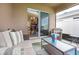 Comfortable covered patio featuring a cozy couch, chair, and view into the home's kitchen at 5416 Tessin Trl, St Cloud, FL 34771