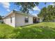 Side view of backyard, showing grass, chain-link fence and back of home at 621 Bluebill Ln, Poinciana, FL 34759
