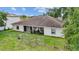 Aerial view of backyard, grass, chain-link fence, and back of home at 621 Bluebill Ln, Poinciana, FL 34759