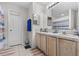 Well-lit bathroom featuring double sinks, a vanity, and a shower-tub combo at 621 Bluebill Ln, Poinciana, FL 34759