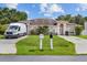 Charming single-story home with arched windows, a green lawn and mature landscaping at 621 Bluebill Ln, Poinciana, FL 34759