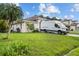 Well-maintained home showcasing lush green lawn, mature palms, and a circular window feature at 621 Bluebill Ln, Poinciana, FL 34759