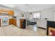 Open kitchen with wood cabinets flowing into a bright living room with stylish furnishings at 621 Bluebill Ln, Poinciana, FL 34759