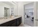 Modern bathroom with dual sinks, granite countertops, and views into the bedroom at 7033 Oakwood St, Davenport, FL 33837