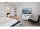 Bright bedroom with a large TV, neutral decor, and en-suite bathroom entrance for modern comfort at 7033 Oakwood St, Davenport, FL 33837