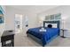 Bedroom featuring blue bedding, accent lamps, and doorway to adjacent room at 7033 Oakwood St, Davenport, FL 33837