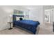 Stylish bedroom with plush blue bed, accent lamps, and soft grey carpet at 7033 Oakwood St, Davenport, FL 33837