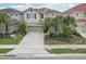 Charming two-story home boasts a well-manicured lawn, mature trees, and a spacious driveway at 7033 Oakwood St, Davenport, FL 33837