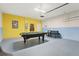 Spacious garage with a pool table, additional seating, and unique color-blocked walls for added flair at 7033 Oakwood St, Davenport, FL 33837