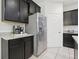 Kitchen featuring stainless steel refrigerator, granite countertops, dark wood cabinetry and tiled floors at 7033 Oakwood St, Davenport, FL 33837