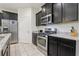Kitchen includes stainless steel appliances, granite countertops, and dark wood cabinetry, with a gas range stove at 7033 Oakwood St, Davenport, FL 33837