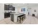 The kitchen offers a large island with seating, stainless steel appliances, and artwork adorning the walls at 7033 Oakwood St, Davenport, FL 33837