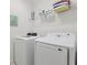 Laundry room featuring modern washer and dryer units and storage shelves at 7033 Oakwood St, Davenport, FL 33837