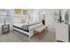 Bright main bedroom with a plush bed, bench, and ample natural light, creating a serene and relaxing retreat at 7033 Oakwood St, Davenport, FL 33837