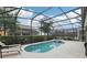 Relaxing screened-in pool and spa offer a private oasis for outdoor enjoyment with lush landscaping at 7033 Oakwood St, Davenport, FL 33837
