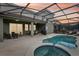 Inviting outdoor living space featuring a screened-in pool, spa, and covered patio for entertaining at 7033 Oakwood St, Davenport, FL 33837