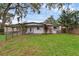 Home exterior showcasing a large, level, grassy backyard with trees and partial fencing at 714 28Th St, Orlando, FL 32805