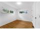 A bright bedroom featuring hardwood floors, white walls, and natural light from two windows at 714 28Th St, Orlando, FL 32805