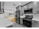 Well-lit kitchen with stainless steel appliances and gray cabinetry, flowing into the living area at 714 28Th St, Orlando, FL 32805