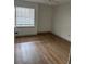A bright, empty bedroom featuring wood-look flooring and a window with blinds at 7350 Westpointe Blvd # 234, Orlando, FL 32835