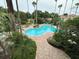 Large community pool surrounded by palm trees and greenery at 7350 Westpointe Blvd # 234, Orlando, FL 32835