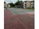 Community tennis court with fencing and apartment buildings at 7350 Westpointe Blvd # 234, Orlando, FL 32835
