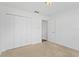 A bright bedroom with neutral carpet, white walls, a closet, and a doorway at 7744 Country Run Pkwy, Orlando, FL 32818