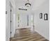 Bright foyer with hardwood floors, white walls, and a decorative light fixture welcomes you inside at 7744 Country Run Pkwy, Orlando, FL 32818