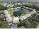 Aerial view of community buildings surrounding a pond, pool, and lush landscaping at 8211 Sun Spring Cir # 11, Orlando, FL 32825