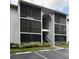 Exterior view of building with screened in patios, parking, and landscaped bushes at 8211 Sun Spring Cir # 11, Orlando, FL 32825