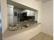 Kitchen pass-through with granite counters and white cabinets at 8211 Sun Spring Cir # 11, Orlando, FL 32825