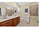 Bathroom with double sinks, wooden cabinets, and a glass-enclosed shower at 8336 Sw 77Th Ct, Ocala, FL 34476
