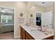 Bathroom with dual vanity sinks and a doorway view into an adjacent bedroom at 8336 Sw 77Th Ct, Ocala, FL 34476