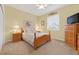 Cozy bedroom with carpeted floors, natural light, and classic wooden furniture at 8336 Sw 77Th Ct, Ocala, FL 34476