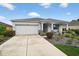 Inviting home with manicured landscaping, cozy front porch seating, and a convenient two-car garage at 8336 Sw 77Th Ct, Ocala, FL 34476