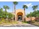 Building entrance with large arched doorway framed by palm trees and landscaped grounds on a sunny day at 879 City Walk Ln, Oviedo, FL 32765