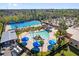 Aerial view of a pool with slides and umbrellas next to the olympic pool, surrounded by trees at 879 City Walk Ln, Oviedo, FL 32765