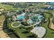Aerial view of luxurious resort-style pool, cabanas, landscaping, parking, and sports facilities at 8986 Cabot Cliffs Dr, Davenport, FL 33896