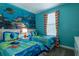 Themed bedroom featuring playful marine life décor, two cozy twin beds, and bright accents at 8986 Cabot Cliffs Dr, Davenport, FL 33896
