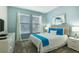 Comfortable bedroom featuring a queen bed with blue accents and a light blue wall color and natural light at 8986 Cabot Cliffs Dr, Davenport, FL 33896