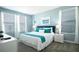 Inviting bedroom showcases natural light, light blue walls, and two windows dressed with white curtains at 8986 Cabot Cliffs Dr, Davenport, FL 33896