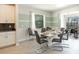 Light filled dining room with a modern table set for six, leading to a screened outdoor patio at 8986 Cabot Cliffs Dr, Davenport, FL 33896