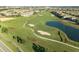 Beautiful aerial view of a lush golf course with a tranquil pond, surrounded by a residential community at 8986 Cabot Cliffs Dr, Davenport, FL 33896